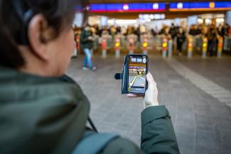 Persoon navigeert met easy ways app naar de poortjes op station Arnhem